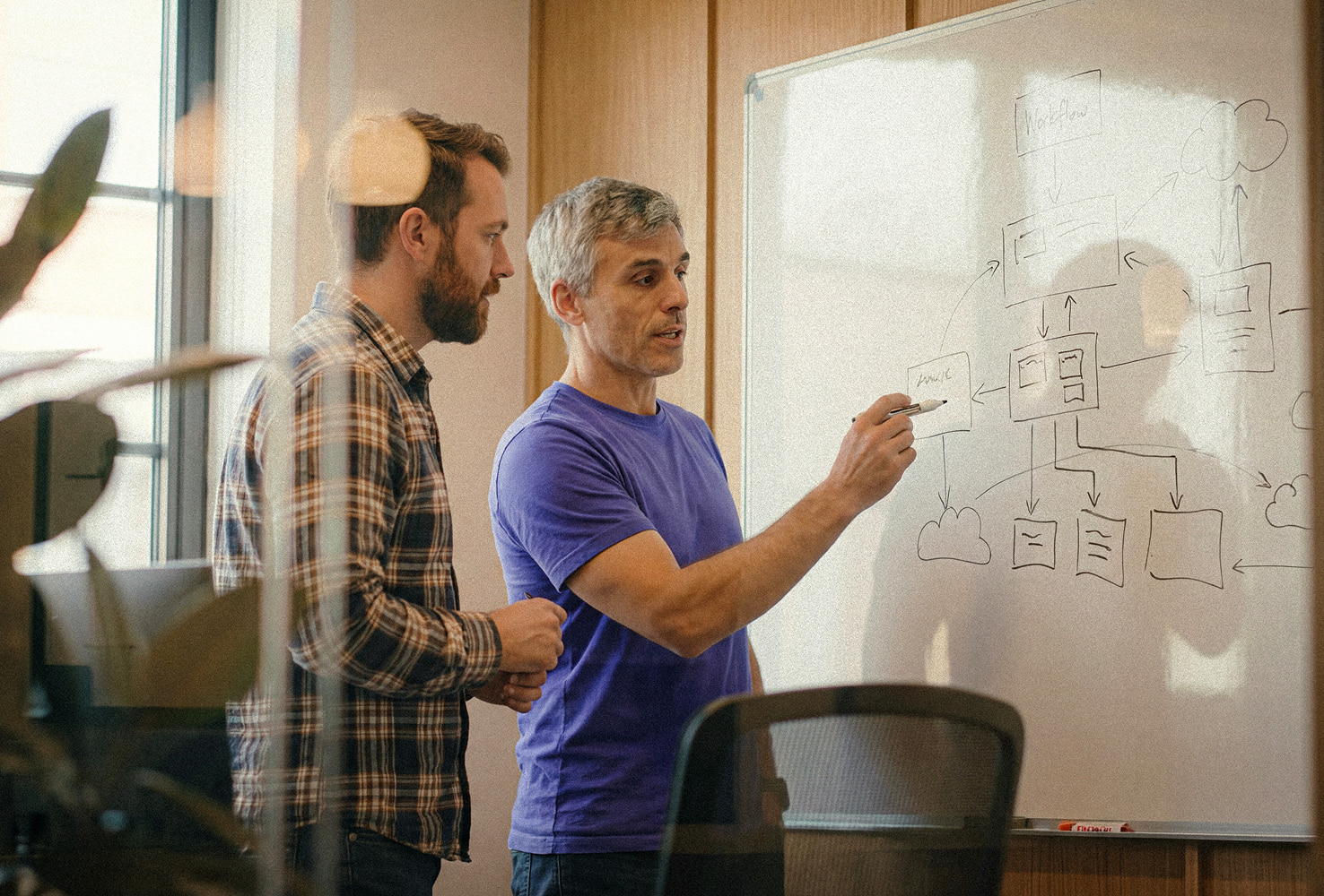 two engineers working side by side at a whiteboard—one Poolside, one customer—sketching out a workflow architecture